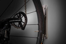 Load image into Gallery viewer, Rear bike wheel resting on Scuff plate against a wall
