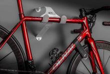 Load image into Gallery viewer, A frozen red Colnago C64 road bike hanging on a Cactus Tongue UNI-XR bike hanger.
